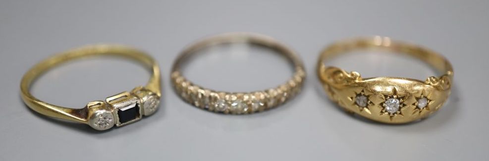 Three assorted 18ct and gem set rings including diamond half eternity and three stone diamond, gross 6.1 grams.